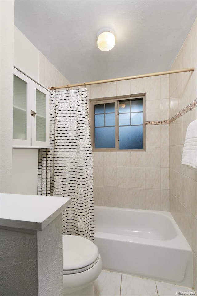 full bath with tile patterned flooring, toilet, tile walls, and shower / bath combo with shower curtain