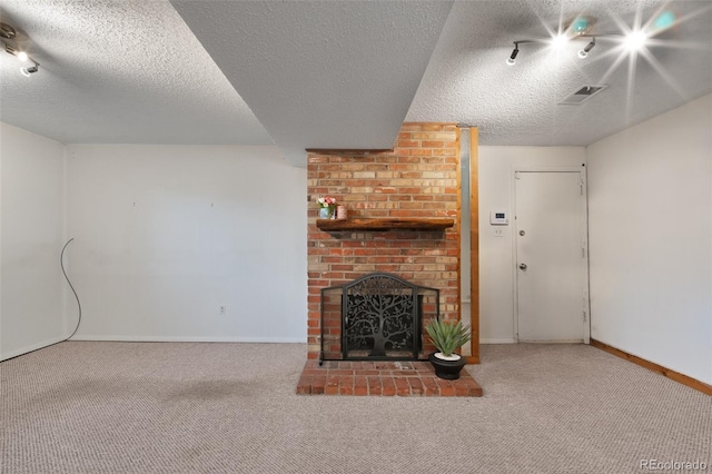 unfurnished living room featuring baseboards, carpet flooring, and a textured ceiling