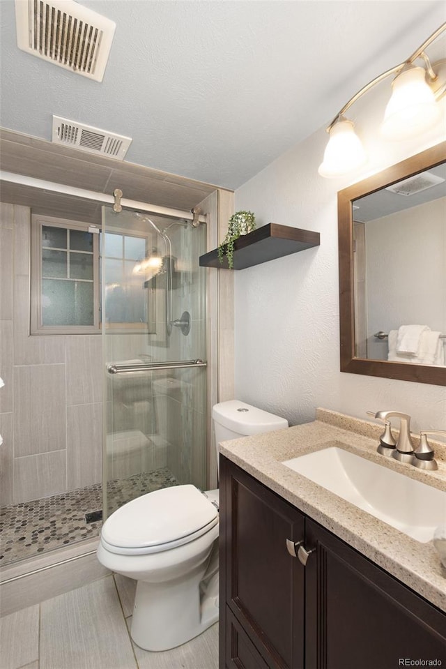 bathroom featuring a stall shower, vanity, and visible vents