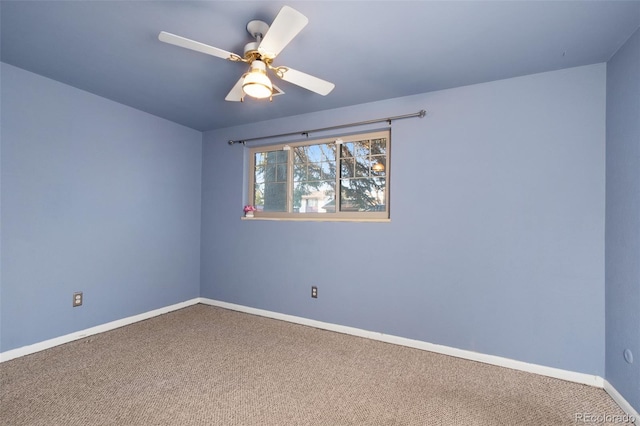 spare room with carpet flooring, baseboards, and a ceiling fan