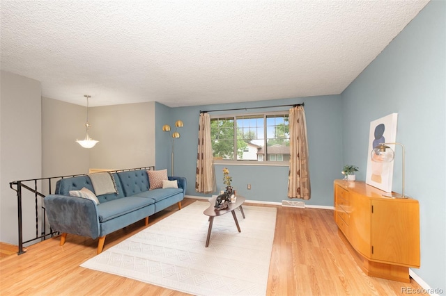 12642 E Ohio Ave, Aurora, CO 80012 - living area featuring light wood finished floors, a textured ceiling, and baseboards