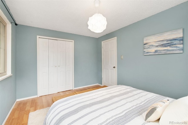 12642 E Ohio Ave, Aurora, CO 80012 - bedroom featuring baseboards, a closet, wood finished floors, and a textured ceiling