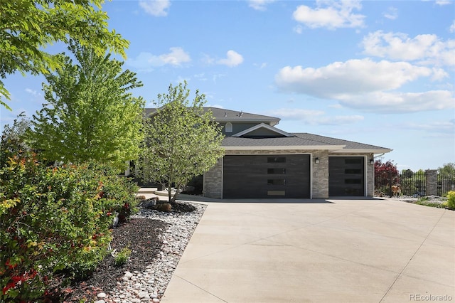 14712 Kalamath Ct, Westminster, CO 80023 - view of front of house featuring a garage, concrete driveway, fence, stone siding, and roof with shingles