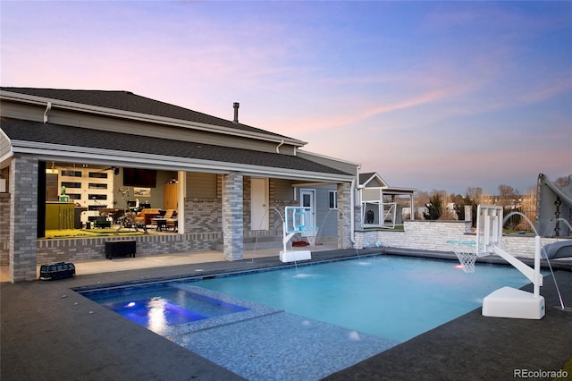 14712 Kalamath Ct, Westminster, CO 80023 - pool at dusk featuring a patio area and a pool with connected hot tub