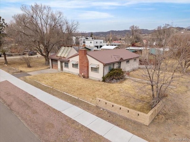 1144 D St, Salida, CO 81201 - exterior space with a front lawn, driveway, a mountain view, and an attached garage