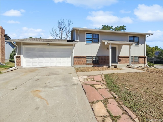 bi-level home featuring a garage, brick siding, and driveway