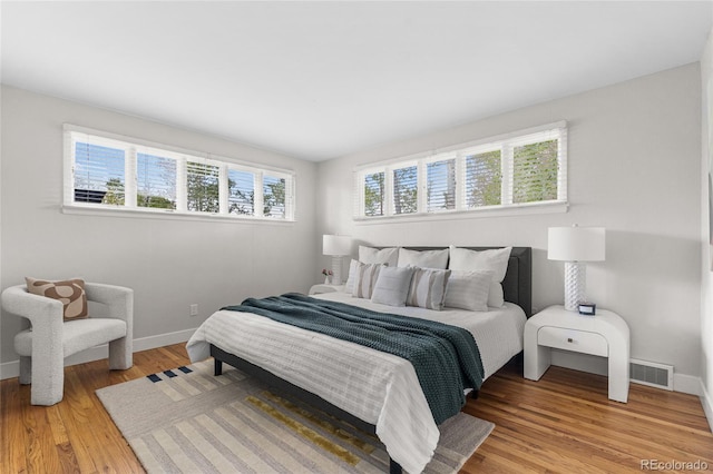 8955 E 19th Ave, Aurora, CO 80010 - bedroom with multiple windows, light wood-type flooring, and baseboards