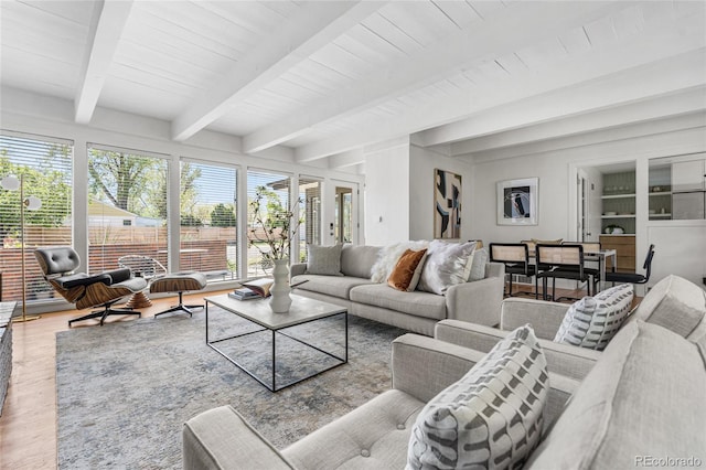 8955 E 19th Ave, Aurora, CO 80010 - living area featuring healthy amount of natural light, wood finished floors, and wooden ceiling with exposed beams