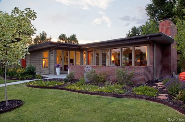 8955 E 19th Ave, Aurora, CO 80010 - view of front of home featuring brick siding, a front yard, and a chimney