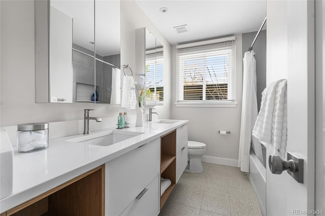 8955 E 19th Ave, Aurora, CO 80010 - bathroom featuring baseboards, double vanity, toilet, and shower / bath combo