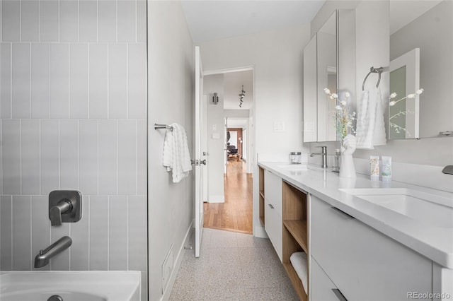 8955 E 19th Ave, Aurora, CO 80010 - bathroom with double vanity, baseboards, and shower / tub combination
