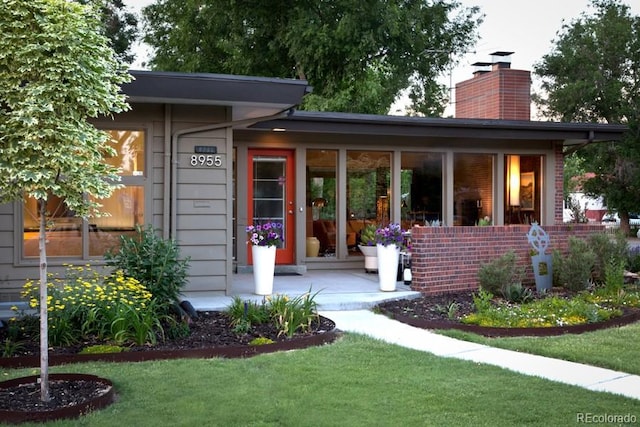 8955 E 19th Ave, Aurora, CO 80010 - back of house featuring a chimney and a lawn