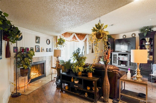 995 Holli Springs Ln, Colorado Springs, CO 80907 - living room featuring a textured ceiling, wood finished floors, and a tile fireplace