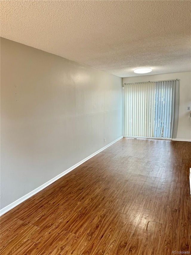 empty room featuring hardwood / wood-style flooring and a textured ceiling