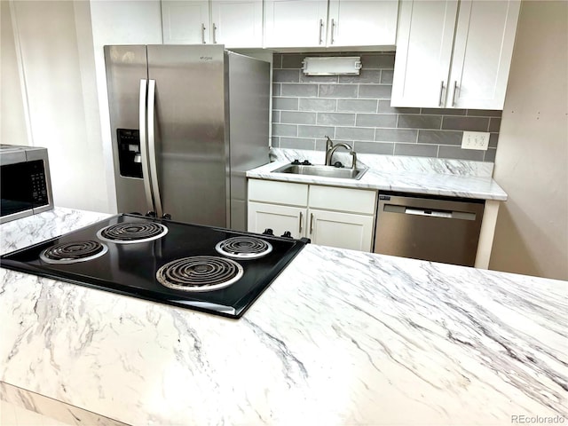 kitchen featuring backsplash, appliances with stainless steel finishes, sink, and light stone counters