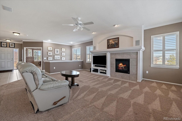 living area with light carpet, a healthy amount of sunlight, and a tiled fireplace