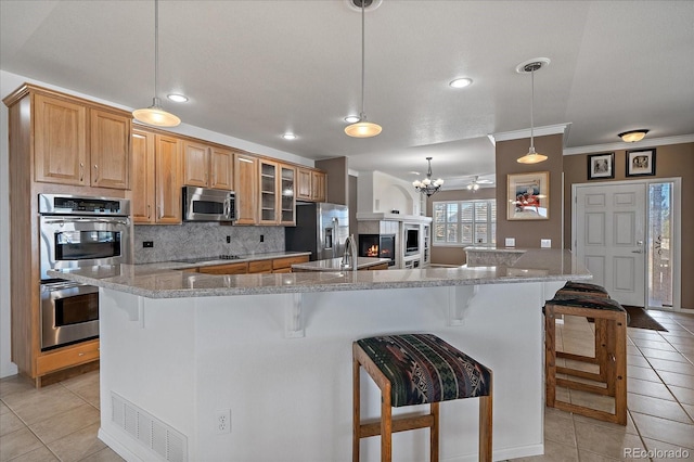 kitchen featuring glass insert cabinets, a large island, visible vents, and appliances with stainless steel finishes