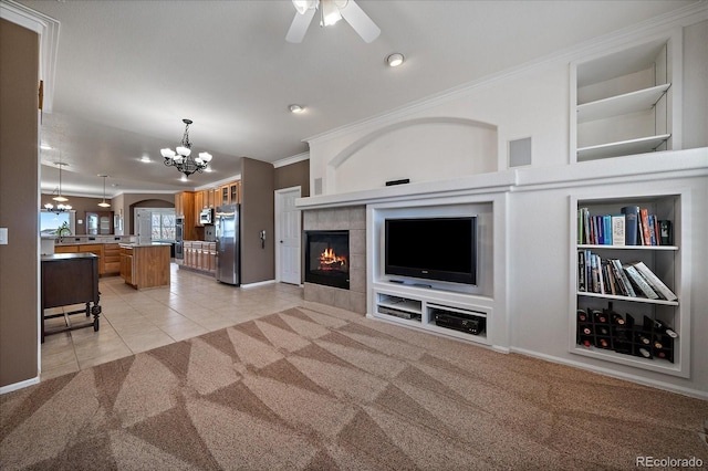 living area featuring light carpet, built in shelves, crown molding, and light tile patterned flooring