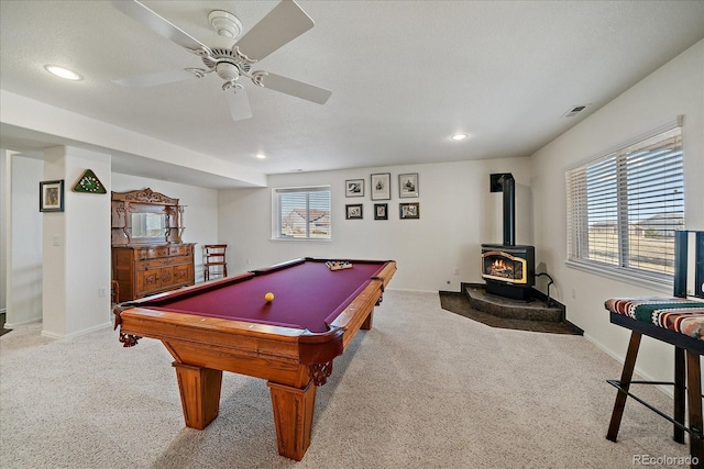 rec room with light carpet, recessed lighting, a wood stove, and baseboards