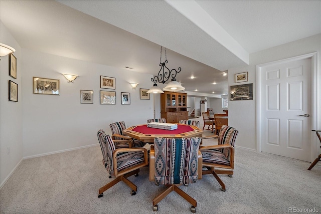 dining area featuring light carpet and baseboards