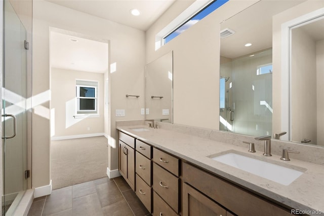 bathroom with a shower with door, tile patterned floors, and vanity