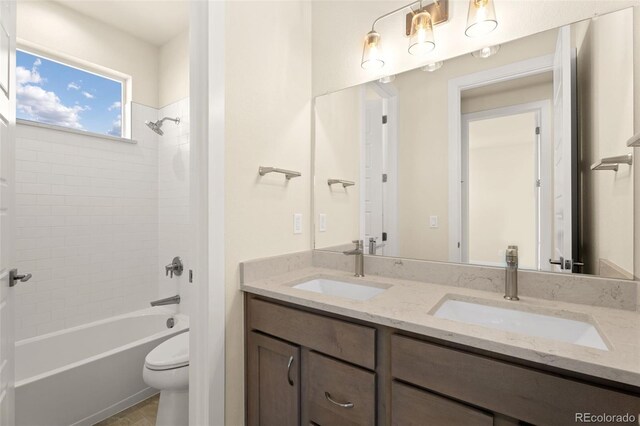 full bathroom with tiled shower / bath combo, toilet, and vanity