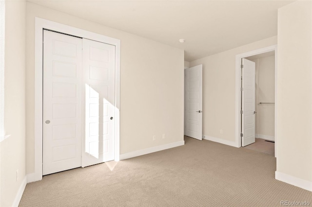 unfurnished bedroom with light carpet and a closet