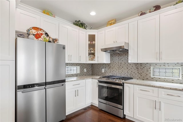 kitchen featuring decorative backsplash, white cabinetry, stainless steel appliances, and light stone counters