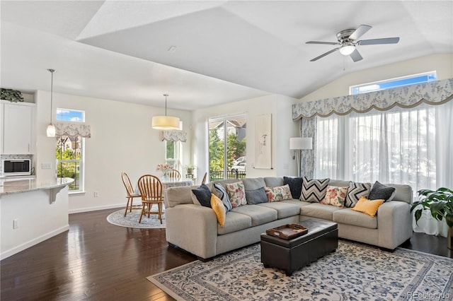 living room featuring lofted ceiling, dark hardwood / wood-style floors, ceiling fan, and a healthy amount of sunlight