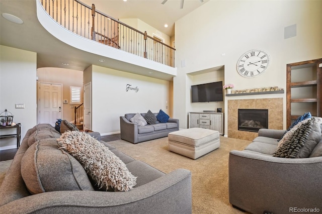 living room featuring a towering ceiling, light carpet, and a fireplace