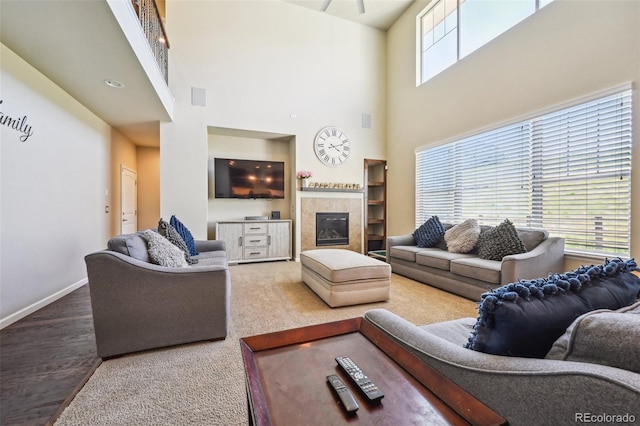 living room with a towering ceiling and a tile fireplace