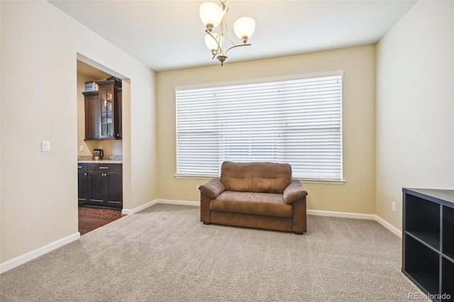 living area featuring a notable chandelier, plenty of natural light, and carpet flooring