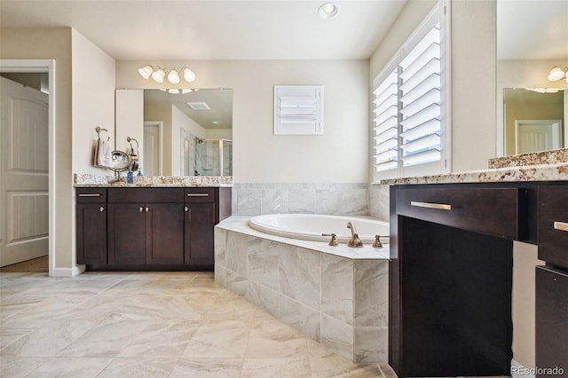 bathroom with vanity and shower with separate bathtub