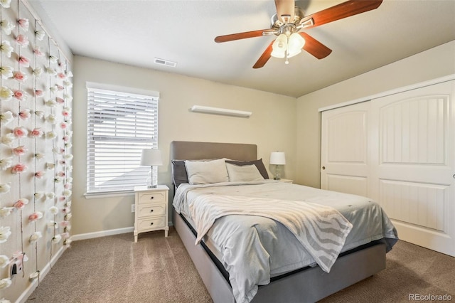 carpeted bedroom featuring ceiling fan and a closet