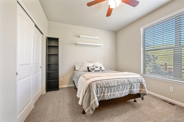 carpeted bedroom with ceiling fan and a closet