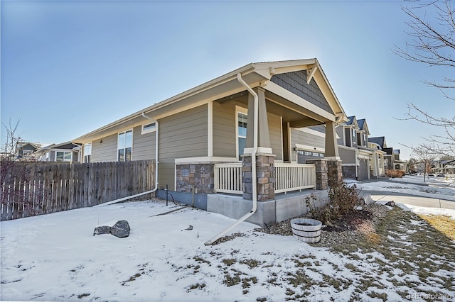 snow covered property featuring covered porch