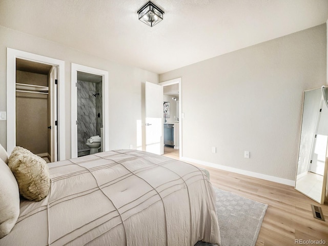 bedroom featuring a closet, light hardwood / wood-style floors, and connected bathroom