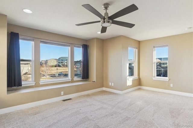 empty room featuring ceiling fan and light colored carpet