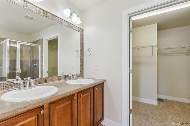 bathroom featuring backsplash, vanity, and an enclosed shower