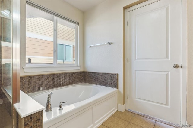 bathroom with tile patterned flooring and a tub to relax in