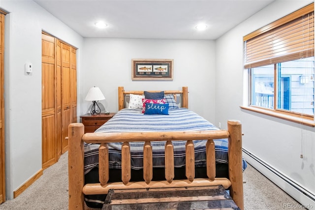 bedroom featuring light colored carpet and baseboard heating