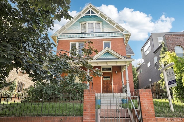 1215 N Emerson St Unit A, Denver, CO 80218 - victorian home featuring a fenced front yard, brick siding, and a gate