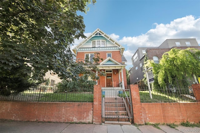 1215 N Emerson St Unit A, Denver, CO 80218 - victorian home featuring a fenced front yard, a gate, and brick siding