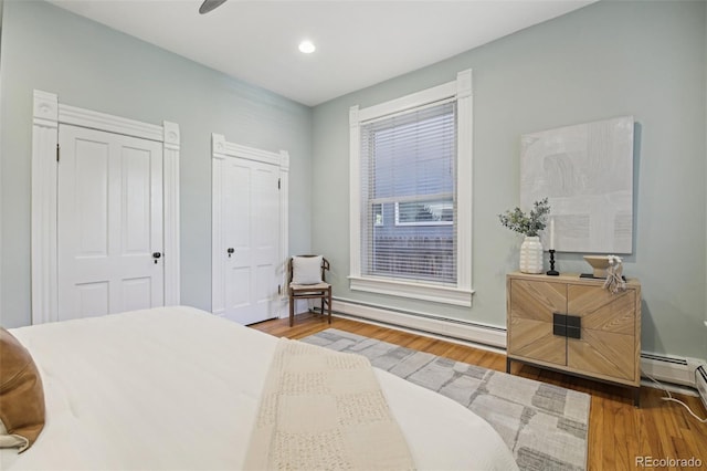 1215 N Emerson St Unit A, Denver, CO 80218 - bedroom featuring wood finished floors, baseboard heating, recessed lighting, and multiple closets