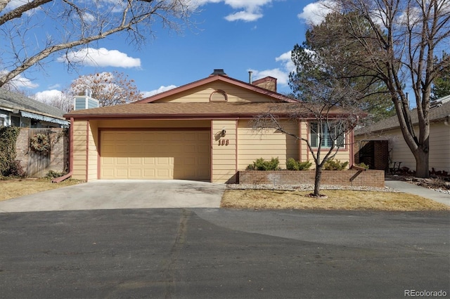 ranch-style home featuring an attached garage, a chimney, and concrete driveway