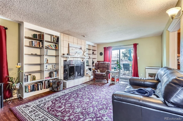 living room with hardwood / wood-style flooring, a fireplace, and a textured ceiling