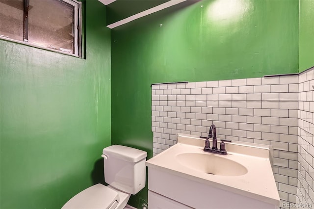 bathroom featuring vanity, tile walls, and toilet