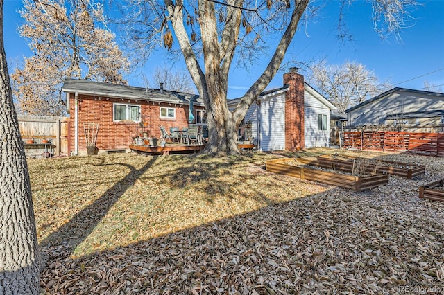 back of property with a lawn and a wooden deck