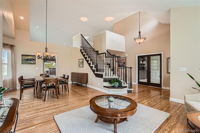 19770 E Geddes Pl, Centennial, CO 80016 - living area with a chandelier, stairs, high vaulted ceiling, light wood finished floors, and baseboards