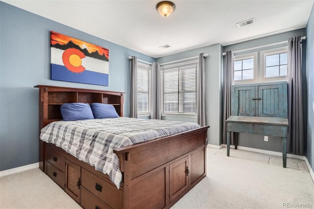 bedroom featuring visible vents, multiple windows, and light colored carpet